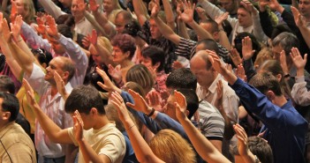 Can White Mainline Churches Outside the South Reach New Christians? Stock photo of a large group of white people extending their arms upward during worship